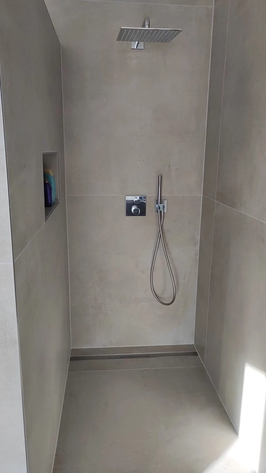 Bodengleiche Dusche in Betonoptik mit eingelassener Ablage