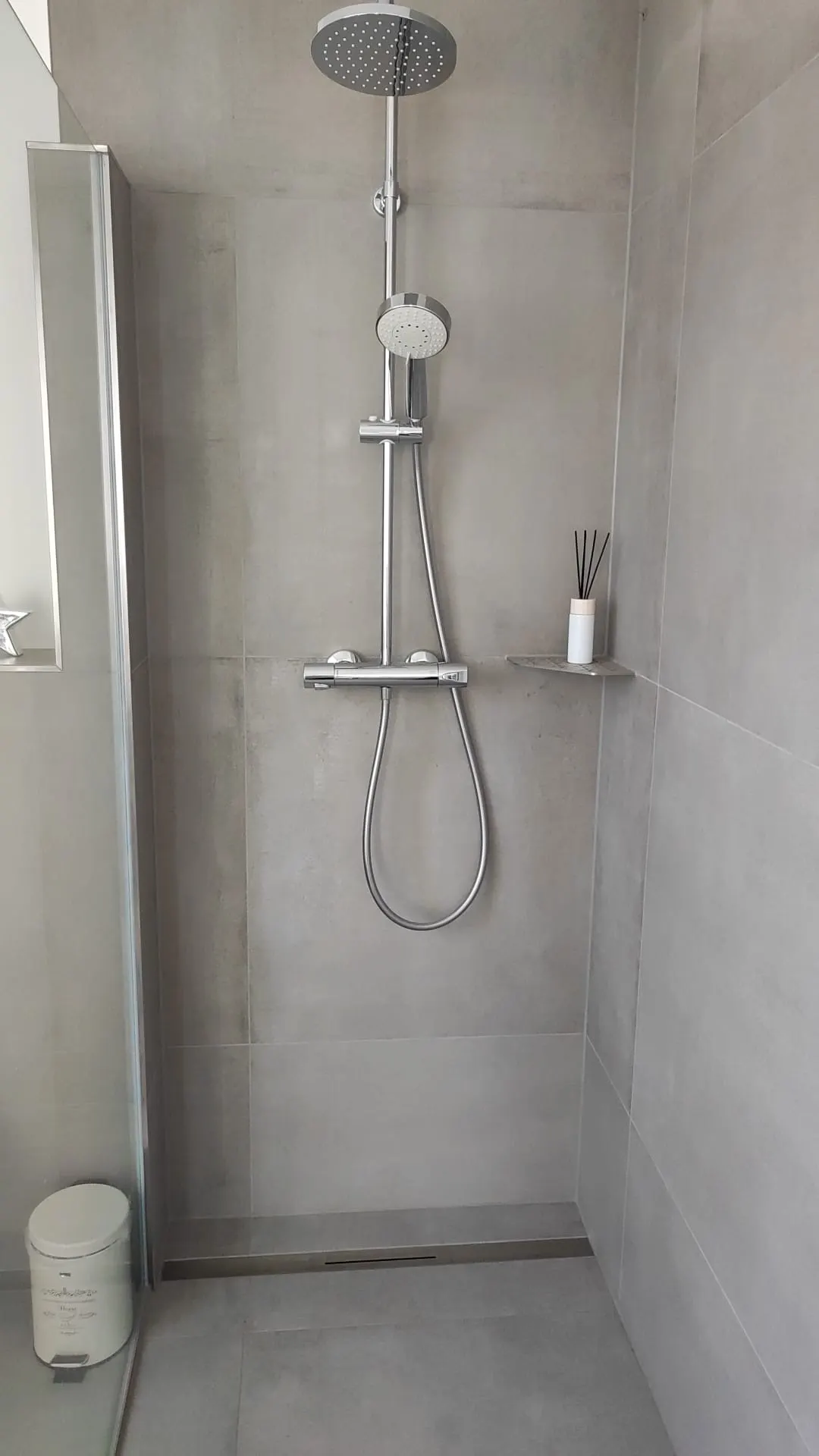 Dusche in Betonoptik mit Ablagefach und Handbrause