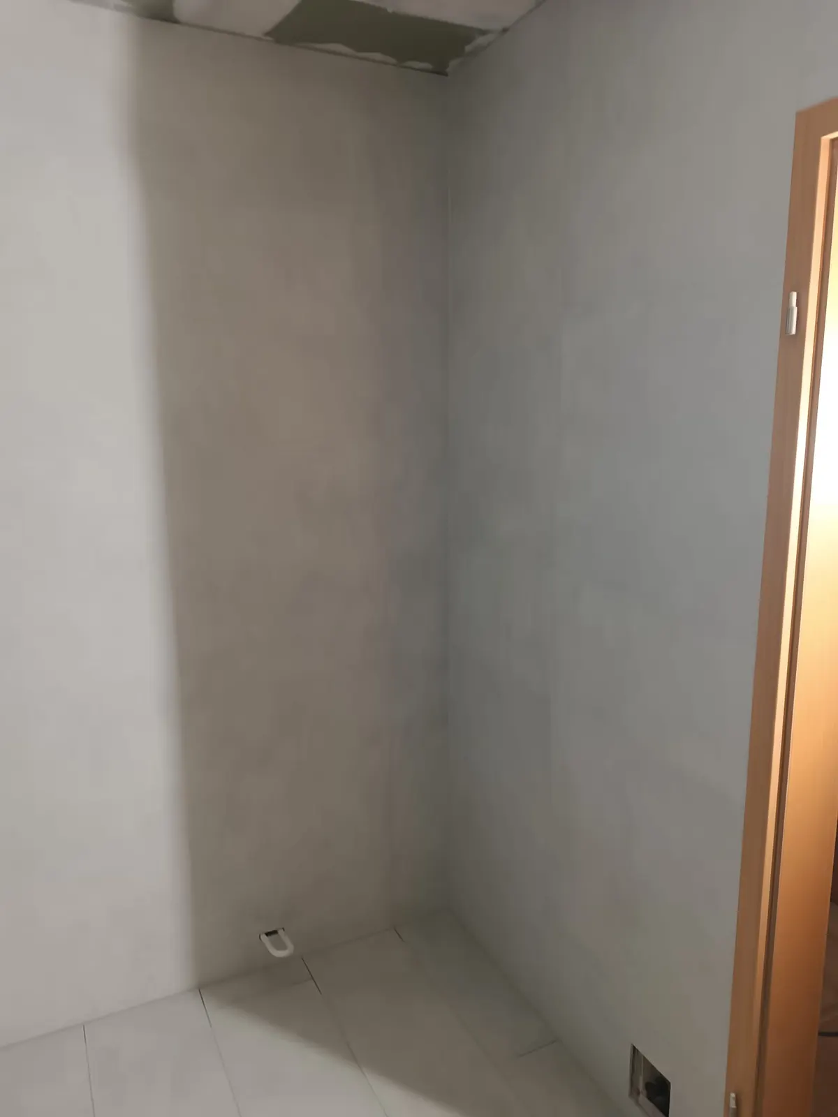 Bodengleiche Dusche mit heller Wandfliese und Ablauf