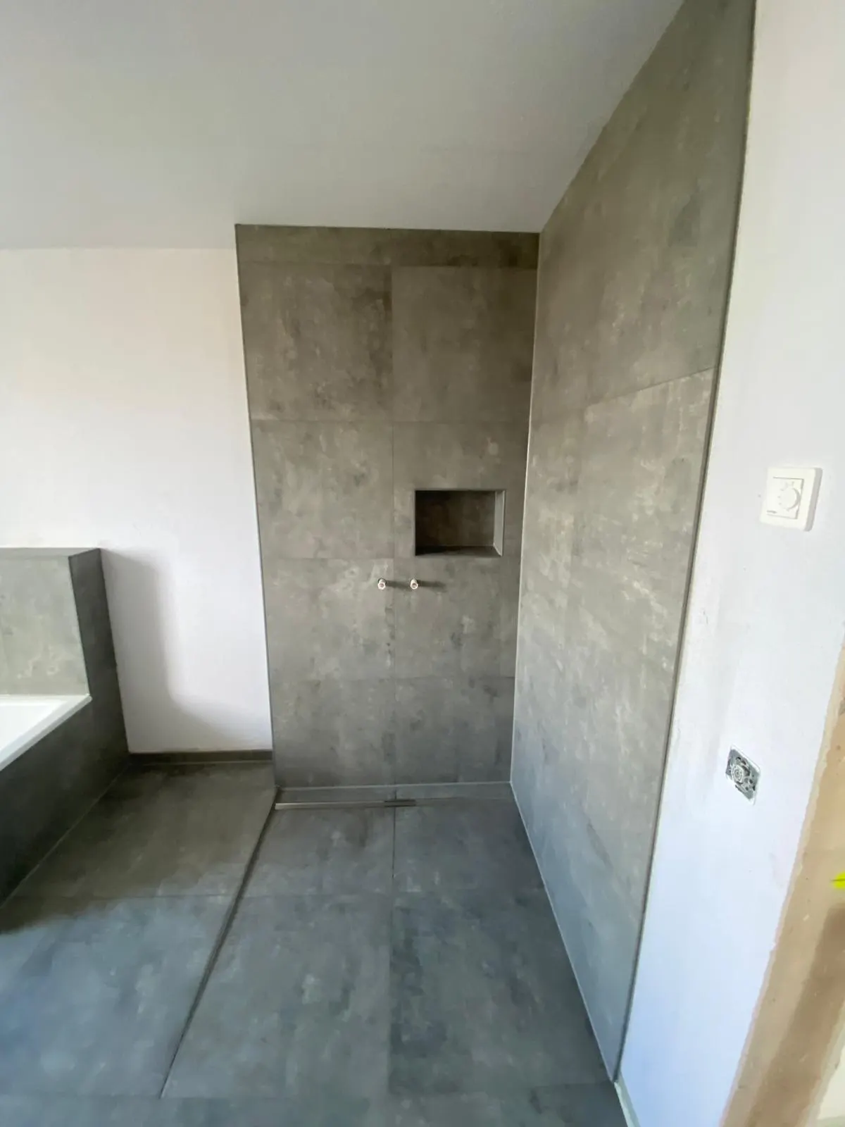 Dusche in Betonoptik mit eingelassener Wandnische