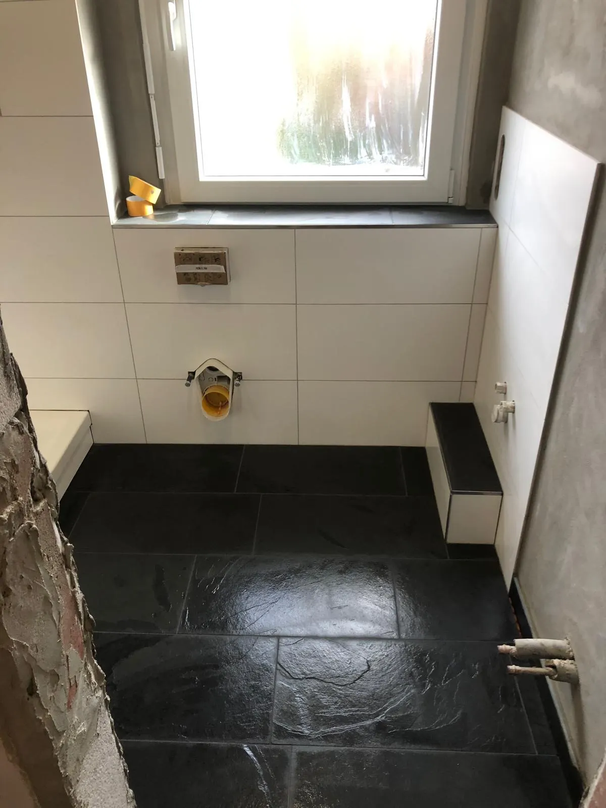 Bad mit dunklem Schieferboden und heller Wandfliese