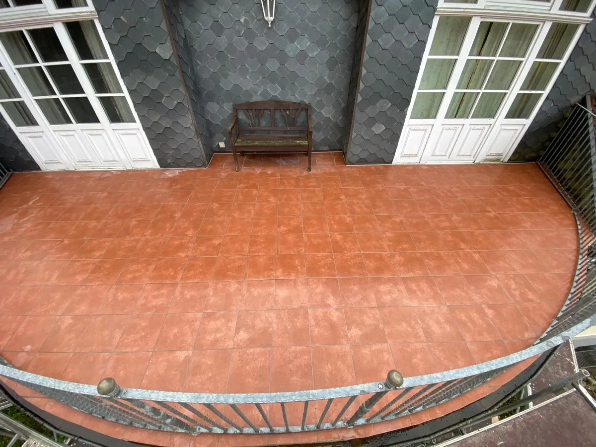 Überdachte Terrasse mit rötlichem Plattenbelag